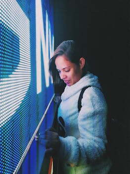A woman interacts with a digital LED display, creating a modern aesthetic.